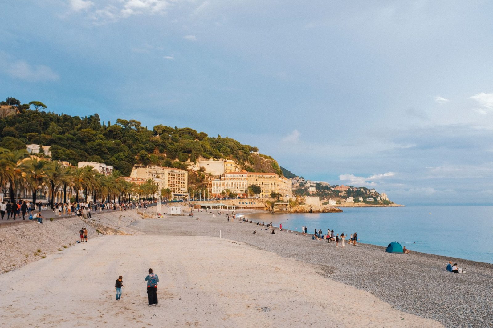 A picturesque beach in a mediterranean town with people enjoying leisure time