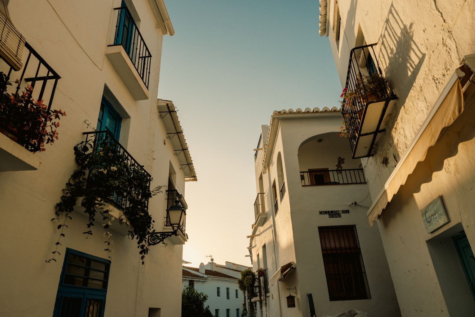 A picturesque mediterranean alley with whitewashed buildings and vibrant colour